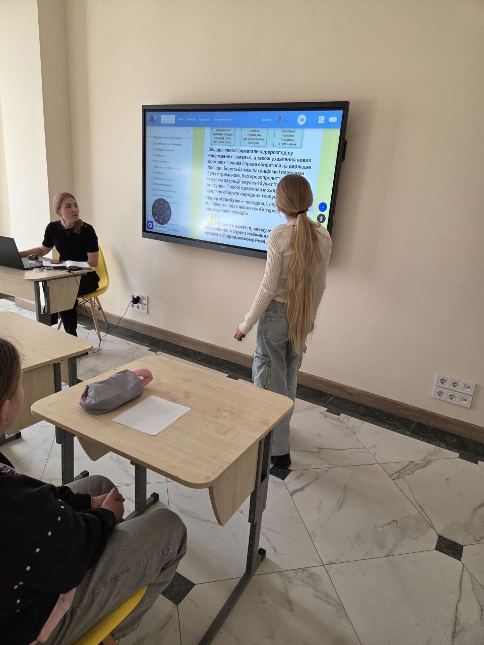 Учениця біля інтерактивної панелі